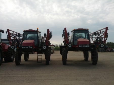 These grasshopper-looking guys are high-clearance sprayers.  They are used for spraying fertilizer or pesticides onto crops without mashing them- the wheels  fit between rows (Almost)