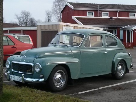 Retro Volvo in Sweden, in front of a charming red house.