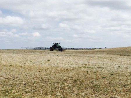 A high-clearance sprayer.  this is a new fangled self-propelled machine designed to deliver fertilizer and pesticides.  Usually span about 100ft, and fold up for travel on country roads