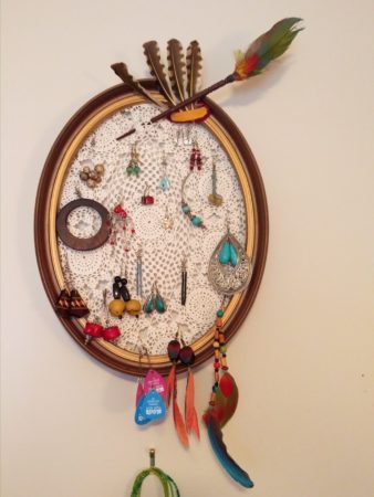 A doily stretched over a frame for earrings and such